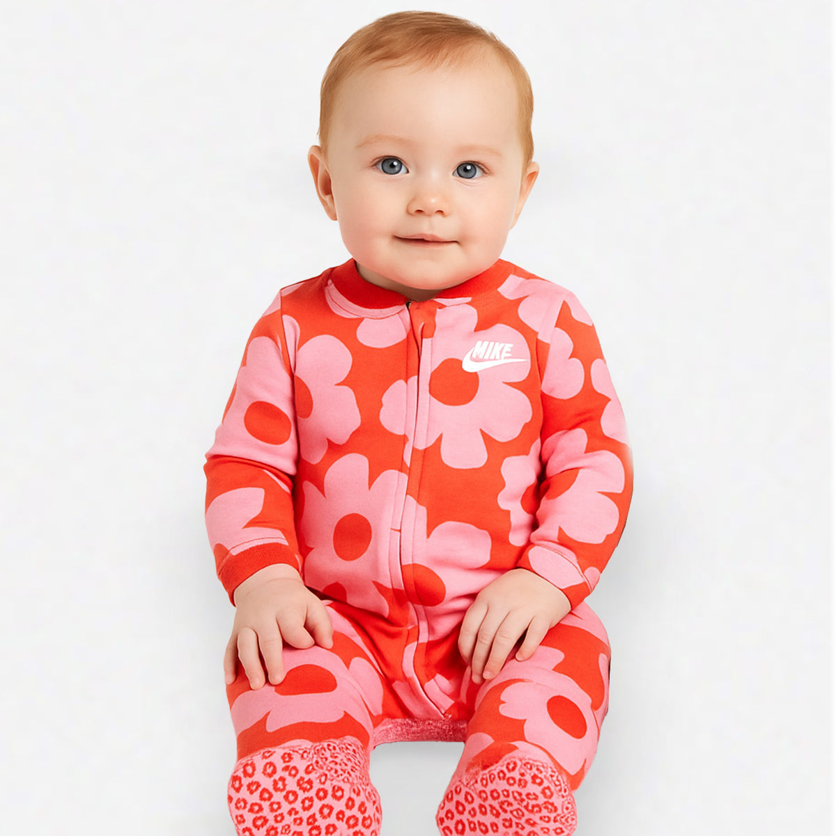 Baby Nike NKG Floral Coverall in Picante Red with bold pink floral print, full-length zipper, long sleeves, and footed design made of 100% soft cotton.